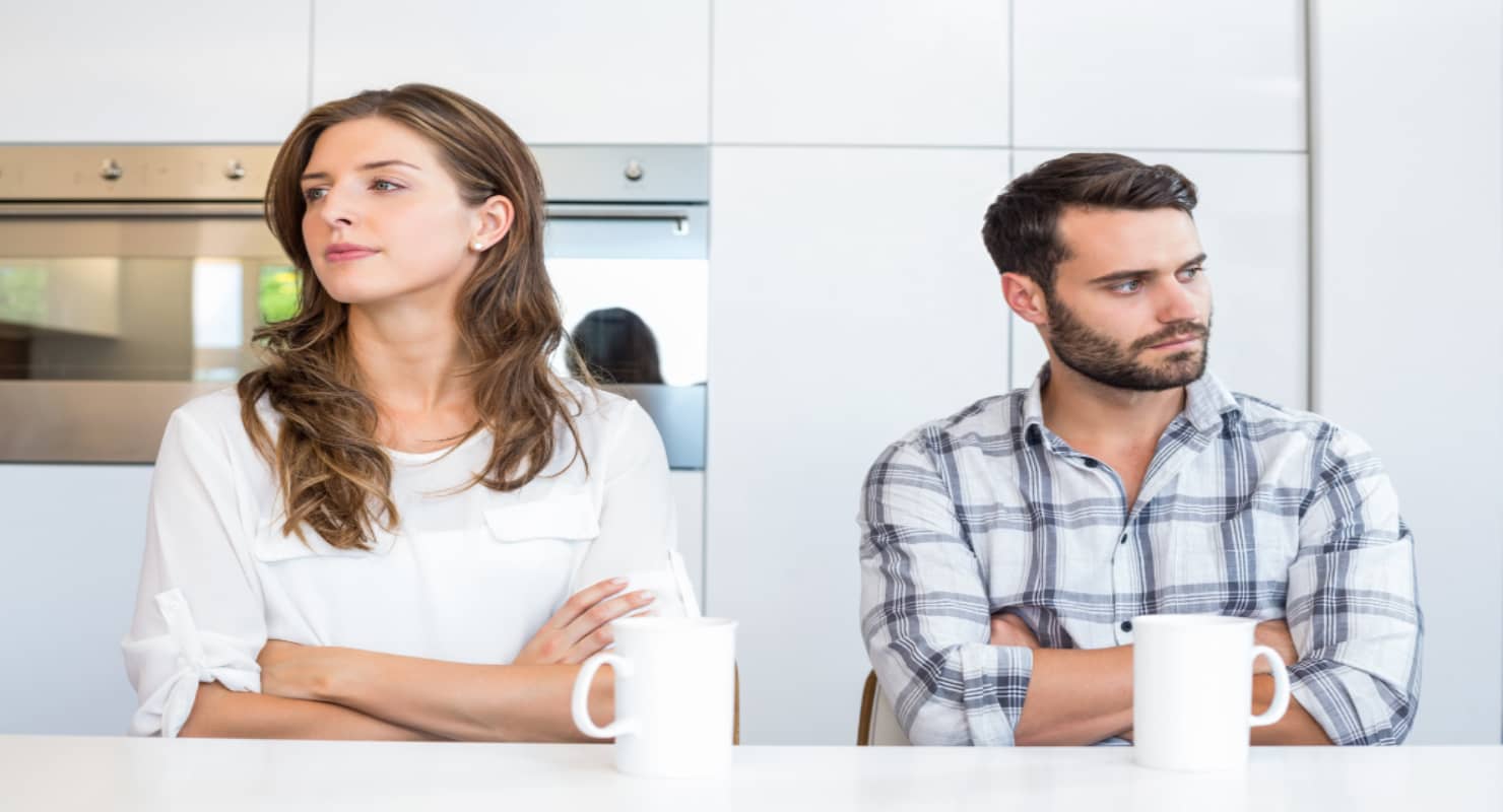 Upset couple sitting by table