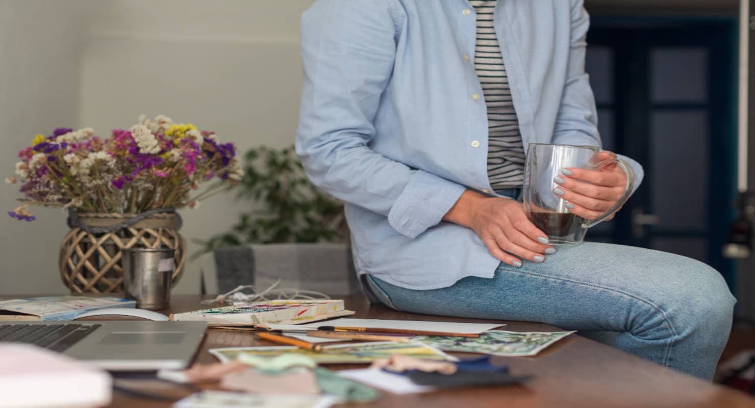 Unrecognisable woman sitting on messy desk