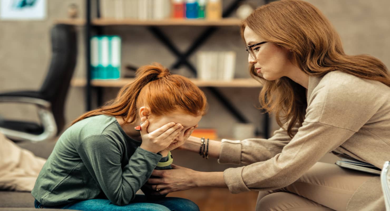 So sad. Pretty red haired girl crying while with mom
