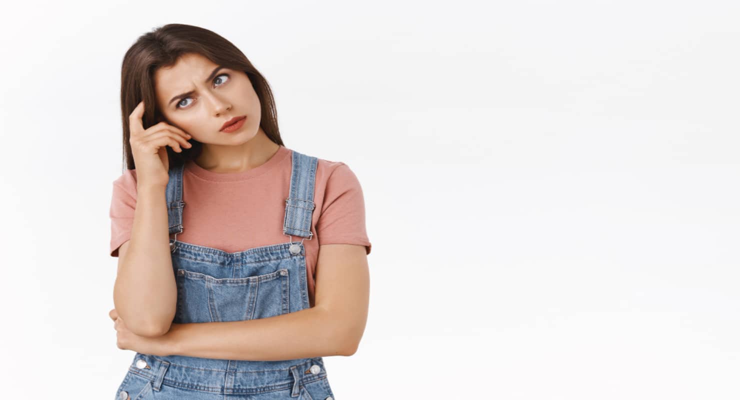 Girl troubled to solve puzzle, standing confused