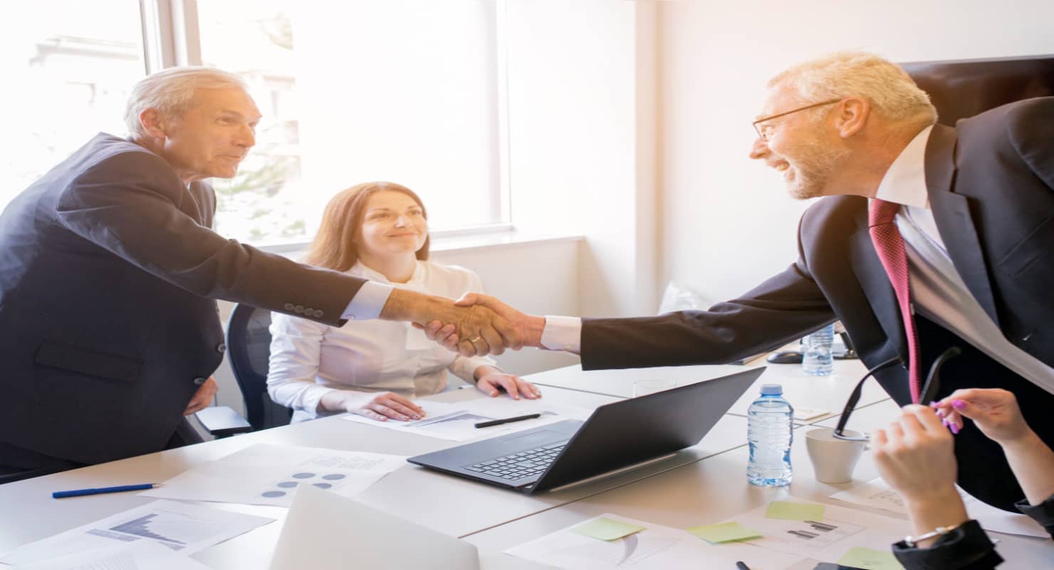 Smiling woman looking at two senior businessman