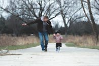 A Father and his Little Girl Running on a Park Pathway